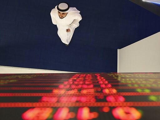 An Emirati trader checks the stocks on the screen at the Dubai Financial Market in Dubai, United Arab Emirates, Sunday, March 8, 2020. Stocks markets in the Mideast suffered sharp drops in early trading Sunday over fears about the new coronavirus and demand in crude oil falling amid a failure by OPEC and allied nations to cut production. (AP Photo/Kamran Jebreili)