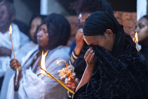 Ethiopian relatives of some of the crash victims light candles and gather at an anniversary memorial service to remember those who died when Ethiopian Airlines flight ET302, a Boeing 737 Max, crashed shortly after takeoff on March 10, 2019 killing all 157 on board, at the Holy Trinity Cathedral in Addis Ababa, Ethiopia Sunday, March 8, 2020. (AP Photo/Mulugeta Ayene)