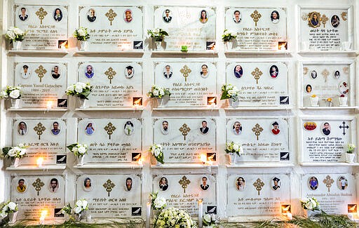 Candles are lit on a memorial wall during an anniversary memorial service to remember those who died when Ethiopian Airlines flight ET302, a Boeing 737 Max, crashed shortly after takeoff on March 10, 2019 killing all 157 on board, at the Holy Trinity Cathedral in Addis Ababa, Ethiopia Sunday, March 8, 2020. (AP Photo/Mulugeta Ayene)