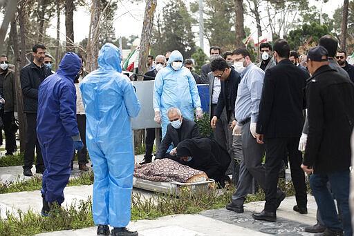 Relatives mourn over the body of Fatemeh Rahbar, a lawmaker-elect from a Tehran constituency, who died on Saturday after being infected with the new coronavirus, at Behesht-e-Zahra cemetery, just outside Tehran, Iran, Sunday, March 8, 2020. Rahbar previously served three terms as lawmaker. With the approaching Persian New Year, known as Nowruz, officials kept up pressure on people not to travel and to stay home. Health Ministry spokesman Kianoush Jahanpour, who gave Iran's new casualty figures Sunday, reiterated that people should not even attend funerals. (Mehdi Khanlari/Fars News Agency via AP)