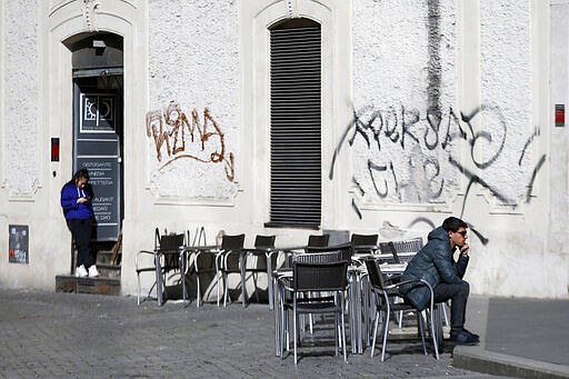 A man sits at a table as others are empty at a cafe in Largo Argentina square amid growing concern about the spread of a new coronavirus in Rome Saturday, March 7, 2020. Italy is taking an almighty hit to its already weak economy from being the focal point of the coronavirus emergency in Europe. (Cecilia Fabiano/LaPresse via AP)