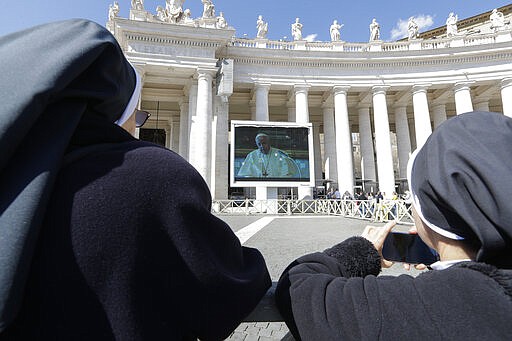 Nuns watch Pope Francis on a giant screen as he delivers the Angelus, in St. Peter's Square, at the Vatican, Sunday, March 8, 2020. Italy's Prime Minister Giuseppe Conte announced a sweeping coronavirus quarantine early Sunday, restricting the movements of about a quarter of the country's population in a bid to limit contagions at the epicenter of Europe's outbreak. (AP Photo/Andrew Medichini)