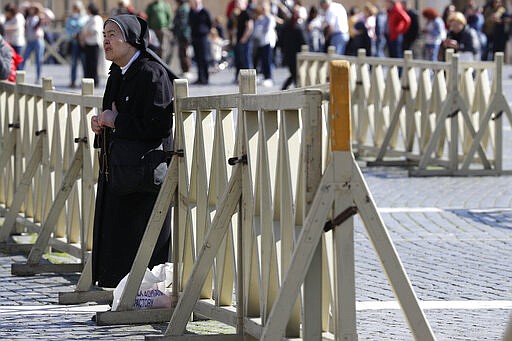 A nun watches Pope Francis on a giant screen as he delivers the Angelus, in St. Peter's Square, at the Vatican, Sunday, March 8, 2020. Italy's Prime Minister Giuseppe Conte announced a sweeping coronavirus quarantine early Sunday, restricting the movements of about a quarter of the country's population in a bid to limit contagions at the epicenter of Europe's outbreak. (AP Photo/Andrew Medichini)