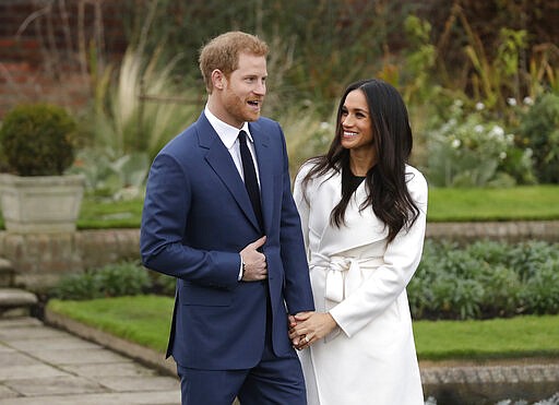 FILE - In this Monday Nov. 27, 2017 file photo, Britain's Prince Harry and his fiancee Meghan Markle pose for photographers  in the grounds of Kensington Palace in London, after announcing their engagement. Prince Harry and his wife, Meghan, are fulfilling their last royal commitment Monday March 9, 2020 when they appear at the annual Commonwealth Service at Westminster Abbey. It is the last time they will be seen at work with the entire Windsor clan before they fly off into self-imposed exile in North America. (AP Photo/Matt Dunham, file)