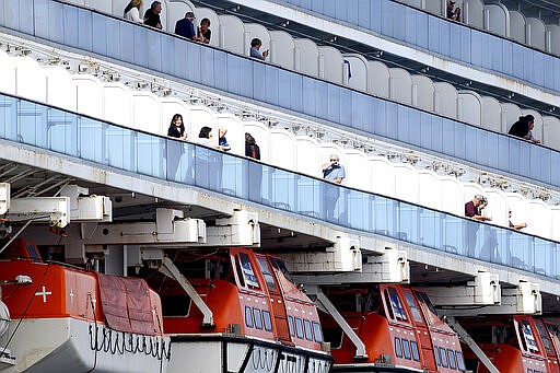 Passengers look out from balconies aboard the Grand Princess as it cruises a holding pattern about 25 miles off the coast of San Francisco on Sunday, March 8, 2020. The ship is expected to dock in Oakland in the east San Francisco Bay on Monday. California Gov. Gavin Newsom and the mayor of Oakland sought Sunday to reassure the public that none of the passengers from the ship with multiple cases of the new coronavirus will be released into the public before undergoing a 14-day quarantine. (AP Photo/Noah Berger)