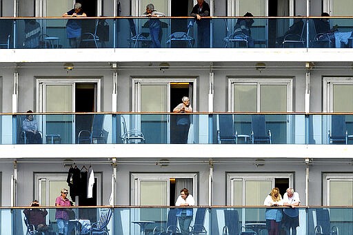 Passengers look out from balconies aboard the Grand Princess as it cruises a holding pattern about 25 miles off the coast of San Francisco on Sunday, March 8, 2020. The ship is expected to dock in Oakland in the east San Francisco Bay on Monday. California Gov. Gavin Newsom and the mayor of Oakland sought Sunday to reassure the public that none of the passengers from the ship with multiple cases of the new coronavirus will be released into the public before undergoing a 14-day quarantine. (AP Photo/Noah Berger)