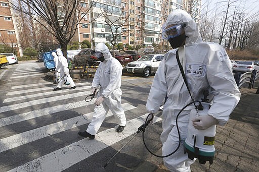 South Korean army soldiers spray disinfectant as a precaution against a new coronavirus on a street in Seoul, South Korea, Monday, March 9, 2020. (AP Photo/Ahn Young-joon)