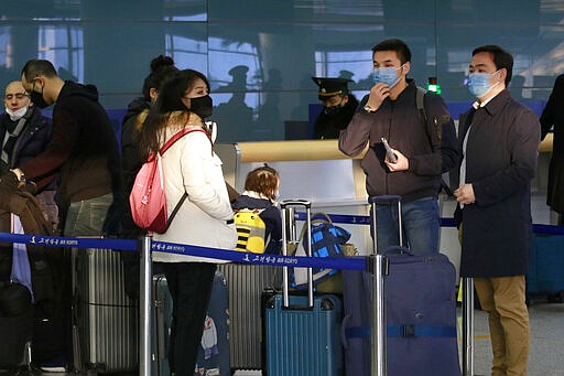 Passengers wearing masks as a precaution against a new coronavirus line up to check in for a flight to Vladivostok, Russia, at the Pyongyang International Airport in Pyongyang, North Korea, Monday, March 9, 2020. (AP Photo/Jon Chol Jin)