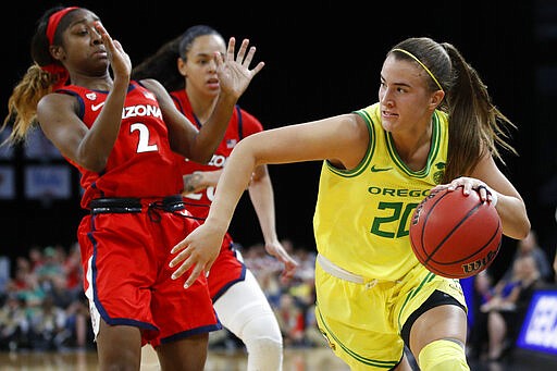 Oregon's Sabrina Ionescu (20) drives around Arizona's Aarion McDonald (2) during the second half of an NCAA college basketball game in the semifinal round of the Pac-12 women's tournament Saturday, March 7, 2020, in Las Vegas. (AP Photo/John Locher)