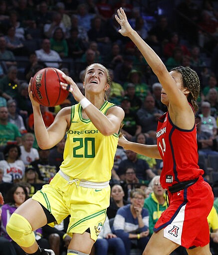 Oregon's Sabrina Ionescu (20) shoots around Arizona's Sam Thomas (14) during the second half of an NCAA college basketball game in the semifinal round of the Pac-12 women's tournament Saturday, March 7, 2020, in Las Vegas. (AP Photo/John Locher)