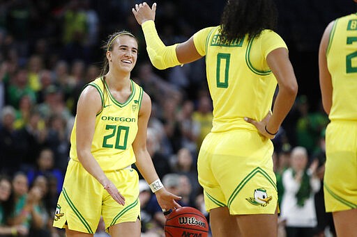 Oregon's Sabrina Ionescu (20) and Satou Sabally (0) celebrate after defeating Arizona in an NCAA college basketball game in the semifinal round of the Pac-12 women's tournament Saturday, March 7, 2020, in Las Vegas. (AP Photo/John Locher)