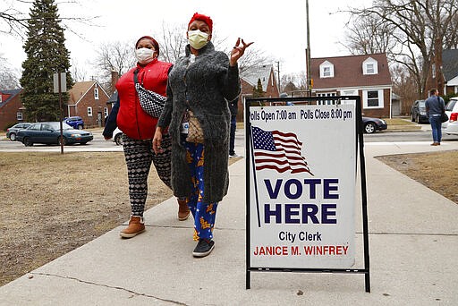 Voters arrive with masks in light of the coronavirus COVID-19 health concern at Warren E. Bow Elementary School in Detroit, Tuesday, March 10, 2020. (AP Photo/Paul Sancya)