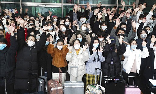 Chinese students wave their hands after they are released from a two-week isolation at a dormitory amid the spread of the coronavirus at the Dankook University in Yongin, South Korea, Tuesday, March 10, 2020. For most people, the new coronavirus causes only mild or moderate symptoms, such as fever and cough. For some, especially older adults and people with existing health problems, it can cause more severe illness, including pneumonia. (Hong Gi-won/Yonhap via AP)