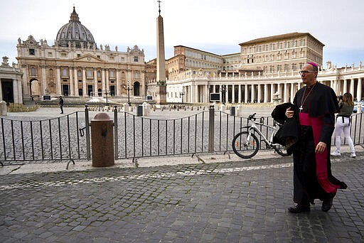 A prelate walks outside St. Peter's Square after the Vatican erected a new barricade at the edge of the square, in Rome, Tuesday, March 10, 2020. Italy entered its first day under a nationwide lockdown after a government decree extended restrictions on movement from the hard-hit north to the rest of the country to prevent the spreading of coronavirus.  (AP Photo/Andrew Medichini)