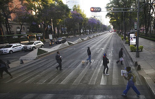 People walk across the Paseo de la Reforma during the national women's strike &quot;A Day Without Women&quot; in Mexico City, Monday, March 9, 2020. Thousands of women across Mexico went on strike after an unprecedented number of girls and women hit the streets to protest rampant gender violence on International Women's Day. (AP Photo/Marco Ugarte)