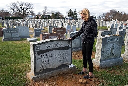 Ashley Govberg of Villanova visits the grave of her grandmother, Frances Salinger, following the unveiling of her headstone at Montefiore Cemetery Tuesday, Nov. 27, 2018 in Abington, Pa. After Salinger's death in 2015 her remains were unclaimed until Montgomery County Deputy Coroner Alex Balacki tracked Govberg down. She had been estranged from her grandmother following her father's passing. (Bill Fraser/Bucks County Courier Times via AP)