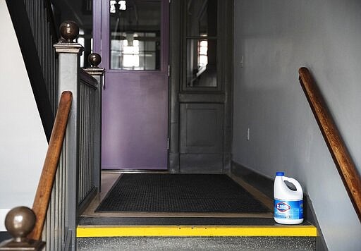 A bottle of bleach sits on the steps of Saint Raphael Academy in Pawtucket, R.I., Friday, March 6, 2020. When the new coronavirus surfaced at the school after a group returned from a trip to Italy, officials decided to close it for two weeks. Instead of cancelling classes, the Catholic school instituted &quot;virtual days&quot; where students are expected to work from home, check for assignments through an online portal and occasionally chat with teachers. For some kids, that means sticking to a strict schedule overseen by parents. For others, the lack of structure has parents wondering if virtual days are an adequate substitute. (AP Photo/David Goldman)