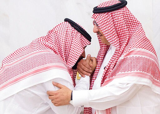 FILE - In this June 21 , 2017 file photo, released by Al-Ekhbariya, Mohammed bin Salman, (MBS) then newly appointed as crown prince, left, kisses the hand of Prince Mohammed bin Nayef at a royal palace in Mecca, Saudi Arabia. King Salman was shown in state media Sunday, March 8, 2020, in apparent good health and working, just days after the arrest of Mohammed bin Nayef and another senior prince triggered speculation about a possible coup attempt or a sudden deterioration in the king's health. (Al-Ekhbariya via AP, File)