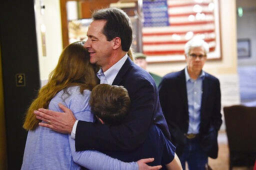 Montana Gov. Steve Bullock hugs his family after filing paperwork to run for U.S. Senate against incumbent Republican Sen. Steve Daines Monday, March 9, 2020 in Helena. (Thom Bridge/Independent Record via AP)