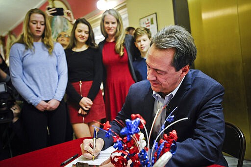 With family members looking on, Montana Gov. Steve Bullock files paperwork to run for U.S. Senate against incumbent Republican Sen. Steve Daines Monday, March 9, 2020 in Helena, Mont. (Thom Bridge/Independent Record via AP)