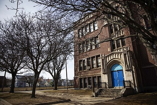 In this March 7, 2020, photo, Achievement First charter school is seen in Providence, R.I. The public charter school, like a nearby Catholic school, closed after a teacher who attended the same Italy trip awaited test results for the new coronavirus. But at Achievement First, the two days off were treated like snow days. There were no special assignments, and no expectation that kids keep up their schoolwork. (AP Photo/David Goldman)