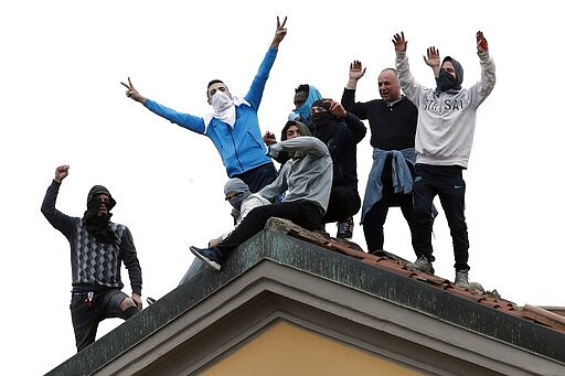 Inmates stage a protest against new rules to cope with coronavirus emergency, atop the roof of the San Vittore prison in Milan, Italy, Monday, March 9, 2020. Italy took a page from China's playbook Sunday, attempting to lock down 16 million people &#151; more than a quarter of its population &#151; for nearly a month to halt the relentless march of the new coronavirus across Europe. (AP Photo/Antonio Calanni)