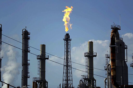 FILE - In this Thursday, Aug. 31, 2017, file photo, a flame burns at the Shell Deer Park oil refinery in Deer Park, Texas. Oil prices are plunging Sunday, March 8, 2020, amid worries that an OPEC dispute will lead a virus-weakened economy to be awash in an oversupply of crude. (AP Photo/Gregory Bull, File)