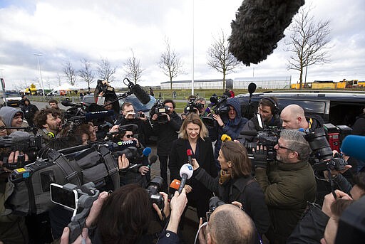 Journalists crowd around members of the Ukrainian delegation outside the court where the trial against four men charged with murder over the downing of Malaysia Airlines flight 17, started at Schiphol airport, near Amsterdam, Netherlands, Monday, March 9, 2020. A missile fired from territory controlled by pro-Russian rebels in Ukraine in 2014, tore the MH17 passenger jet apart killing all 298 people on board. (AP Photo/Peter Dejong)