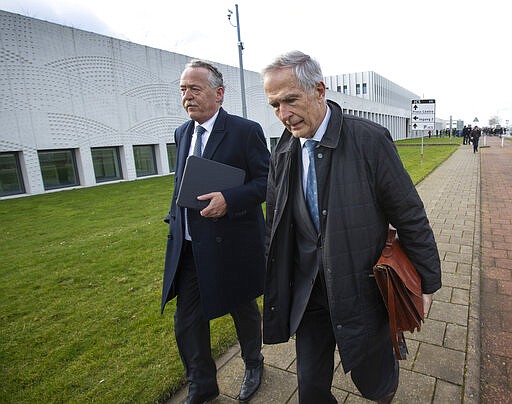 Piet Ploeg, left, who lost his brother, Alex, his sister-in-law and his nephew, and Anton Kotte, right, who lost his son, daughter-in-law and grandson, arrive at the court for the trial of four men charged with murder over the downing of Malaysia Airlines flight 17, at Schiphol airport, near Amsterdam, Netherlands, Monday, March 9, 2020. A missile fired from territory controlled by pro-Russian rebels in Ukraine in 2014, tore the MH17 passenger jet apart killing all 298 people on board. (AP Photo/Peter Dejong)