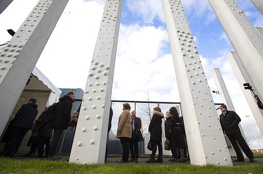 People queue to enter the court for the trial of four men charged with murder over the downing of Malaysia Airlines flight 17, at Schiphol airport, near Amsterdam, Netherlands, Monday, March 9, 2020. A missile fired from territory controlled by pro-Russian rebels in Ukraine in 2014, tore the MH17 passenger jet apart killing all 298 people on board. (AP Photo/Peter Dejong)