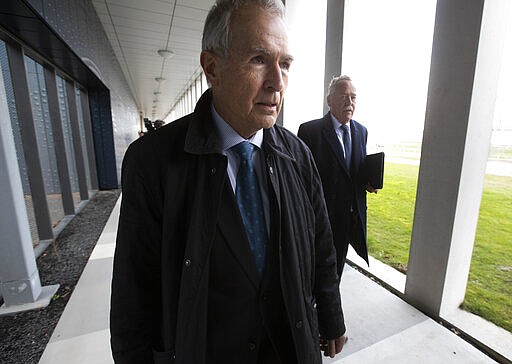 Anton Kotte, left, who lost his son, daughter-in-law and grandson, and Piet Ploeg, right, who lost his brother, Alex, his sister-in-law and his nephew, arrive at the court for the trial of four men charged with murder over the downing of Malaysia Airlines flight 17, at Schiphol airport, near Amsterdam, Netherlands, Monday, March 9, 2020. A missile fired from territory controlled by pro-Russian rebels in Ukraine in 2014, tore the MH17 passenger jet apart killing all 298 people on board. (AP Photo/Peter Dejong)