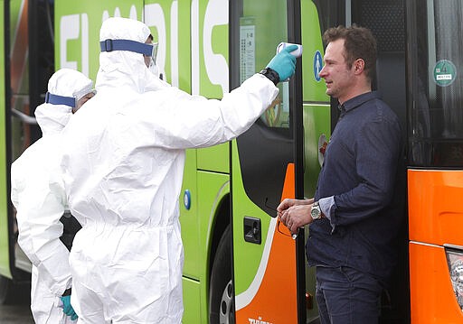 Medical staff measures the temperature of a bus driver at the border crossing with Germany in Rozvadov, Czech Republic, Monday, March 9, 2020. Czech authorities started on Monday random checks of arriving vehicles at the border crossings with Austria, Germany and Slovakia in reaction to the outbreak of the new coronavirus in Europe, particularly in Italy. As part of the move, officials measure the temperatures of some passengers in cars, trucks and buses. (AP Photo/Petr David Josek)