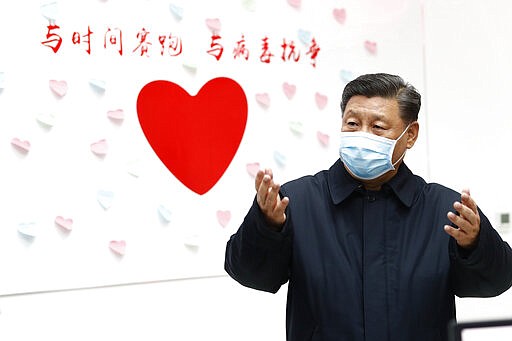 In this Feb. 10, 2020, photo released by Xinhua News Agency, Chinese President Xi Jinping gestures near a heart shape sign and the slogan &quot;Race against time, Fight the Virus&quot; during an inspection of the center for disease control and prevention of Chaoyang District in Beijing. As the rest of the world grapples with a burgeoning virus outbreak, China's ruling Communist Party has turned to its propaganda playbook to portray its leader as firmly in charge, leading an army of health workers in a &quot;people's war&quot; against the disease. (Liu Bin/Xinhua via AP, File)