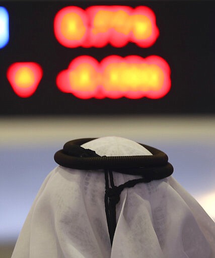 An Emirati trader looks at the latest numbers in red on the screen, at the Dubai Financial Market in Dubai, United Arab Emirates, Monday, March 9, 2020. Saudi Arabia closed off air and sea travel to nine countries affected by the new coronavirus Monday as Mideast stock markets tumbled over fears about the widening outbreak's effect on the global economy. (AP Photo/Kamran Jebreili)