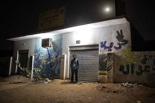 This Jan. 12, 2020 photo shows, Sudanese activist and artist Youssef al-Sewahly stands near graffiti he drew during last years' revolution, on a street in Khartoum, Sudan. When al-Sewahly took to the streets in Sudan late in 2018, he and the other protesters had one goal: to remove the autocratic regime of Omar al-Bashir and replace it with a civilian-led government. They&#146;ve achieved the former, but the latter still hangs in the balance. (AP Photo/Nariman El-Mofty)