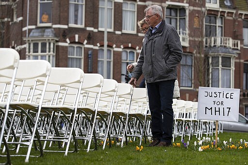 Relatives walk along 298 empty chairs, each chair for one of the 298 victims of the downed Malaysia Air flight MH17, are placed in a park opposite the Russian embassy in The Hague, Netherlands, Sunday, March 8, 2020. A missile fired from territory controlled by pro-Russian rebels in Ukraine in 2014, tore the MH17 passenger jet apart killing all 298 people on board. United by grief across oceans and continents, families who lost loved hope that the trial which starts Monday March 9, 2020, will finally deliver them something that has remained elusive ever since: The truth. (AP Photo/Peter Dejong )