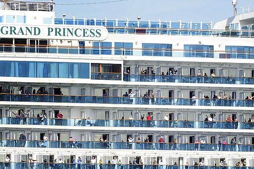 Passenger aboard the Grand Princess celebrate as they arrive in Oakland, Calif., on Monday, March 9, 2020. The cruise ship, which had maintained a holding pattern off the coast for days, is carrying multiple people who tested positive for COVID-19, a disease caused by the new coronavirus. (AP Photo/Noah Berger)