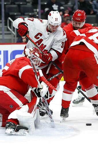 Carolina Hurricanes right wing Andrei Svechnikov (37) tries to get to the puck in front of Detroit Red Wings goaltender Jonathan Bernier (45) during the first period of an NHL hockey game Tuesday, March 10, 2020, in Detroit. (AP Photo/Duane Burleson)