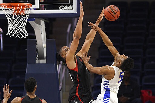 Northeastern guard Max Boursiquot blocks a shot by Hofstra guard Eli Pemberton (5) during the first half of an NCAA college basketball game for the championship of the Colonial Athletic Association men's tournament Tuesday, March 10, 2020, in Washington. (AP Photo/Nick Wass)