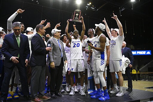 Hofstra guard Jalen Ray (20) and others raise the trophy after defeating Northeastern in an NCAA college basketball game for the championship of the Colonial Athletic Association men's tournament Tuesday, March 10, 2020, in Washington. Hofstra won 70-61. (AP Photo/Nick Wass)