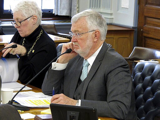 Alaska state Sen. Gary Stevens, right, listens during a Legislative Council meeting on Tuesday, March 10, 2020, in Juneau, Alaska. Stevens on Tuesday announced a subcommittee of lawmakers will work on contingency planning for the Legislature surrounding the new coronavirus. (AP Photo/Becky Bohrer)