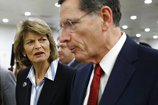 Sen. Lisa Murkowski, R-Alaska, left, speaks Sen. John Barrasso, R-Wyo., on Capitol Hill in Washington after President Donald Trump was acquitted in an impeachment trial on charges of abuse of power and obstruction of Congress, Wednesday, Feb. 5, 2020. (AP Photo/Patrick Semansky)