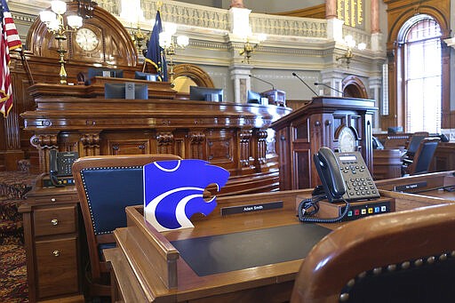 Kansas state Rep. Adam Smith, R-Weskan, honors Kansas State University sports teams with the Wildcat mascot logo, Tuesday, March 10, 2020, on his House chamber desk at the Statehouse in Topeka, Kan. State lawmakers are considering legislation to allow college athletes to hire agents and sign endorsement deals. (AP Photo/John Hanna)