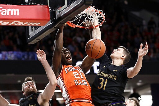 FILE - In this Feb. 27, 2020, file photo, Illinois center Kofi Cockburn, center, reacts as he dunks against Northwestern's Pat Spencer, left, and Robbie Beran during the first half of an NCAA college basketball game in Evanston, Ill. Cockburn was selected Associated Press Big Ten Newcomer of the Year on Tuesday, March 10, 2020.  (AP Photo/Nam Y. Huh, File)