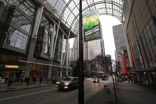 In this March 6, 2020 photo, a sign at the Washington State Convention Center in downtown Seattle promotes the Emerald City Comic Con, which has been postponed over worries and uncertainty about the COVID-19 coronavirus. Hotel bookings in Seattle have dropped as big conventions, including the Comic Con &#151; which organizers hope to reschedule for during the summer &#151; have been postponed or canceled. (AP Photo/Ted S. Warren)