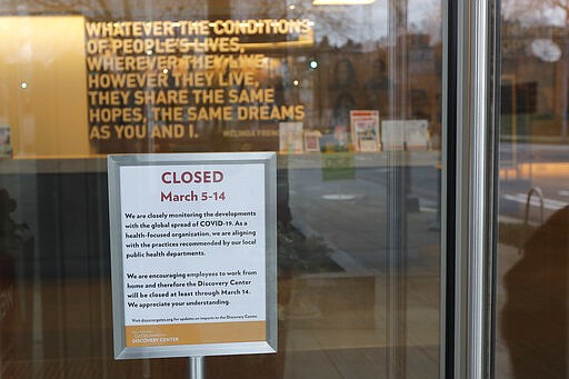 In this March 6, 2020 photo, a sign at the Gates Foundation Discovery Center indicates that the facility, which highlights the public health and other work done world-wide by the Bill and Melinda Gates Foundation, is closed due to worries and uncertainty about the COVID-19 coronavirus. King County has become the epicenter of the outbreak of the virus in the U.S., and local businesses are bracing for the cascading impacts of losing business from customers and tourists for an indeterminate amount of time. (AP Photo/Ted S. Warren)