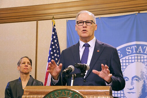 Washington Gov. Jay Inslee, right, talks to the media about the latest actions the state is taking to respond to the coronavirus outbreak, as Employment Security Department Commissioner Suzi LeVine looks on, Tuesday, March 10, 2020, in Olympia, Wash. Inslee announced a list of requirements for long-term care facilities and new rules related to the unemployment insurance program for workers impacted by COVID-19. (AP Photo/Rachel La Corte)