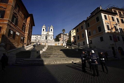 Italian municipality police stand by empty Spanish Steps, in Rome, Tuesday, March 10, 2020. Italy entered its first day under a nationwide lockdown after a government decree extended restrictions on movement from the hard-hit north to the rest of the country to prevent the spreading of coronavirus.  (AP Photo/Andrew Medichini)