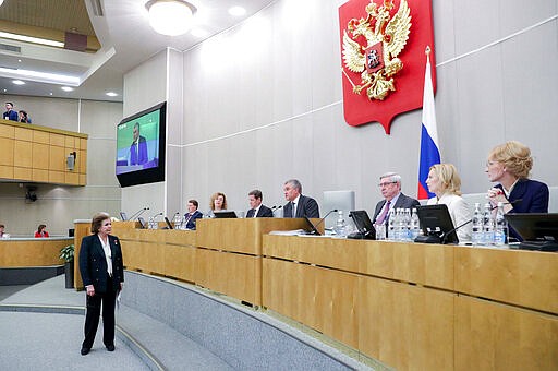 In this handout photo provided by The State Duma, The Federal Assembly of The Russian Federation, the world's first woman cosmonaut Valentina Tereshkova, left, speaks to Russian State Duma speaker Vyacheslav Volodin, fourth right, during a session prior to voting for constitutional amendments at the State Duma, the Lower House of the Russian Parliament in Moscow, Russia, Tuesday, March 10, 2020. Tereshkova, the first woman to have flown in space and a lawmaker with Russia's ruling party, proposed Tuesday to scrap presidential term limits in order to allow Russia President Vladimir Putin to run for re-election in 2024. (The State Duma, The Federal Assembly of The Russian Federation via AP)