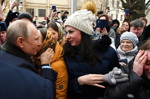 Russian President Vladimir Putin, left, talks with people in Ivanovo, 254 kilometers (158 miles) northeast of Moscow, Russia, Friday, March 6, 2020. Russian President Vladimir Putin said Friday he doesn't want to scrap presidential term limits or resort to other suggested ways of extending his rule, but otherwise he kept mum about his plans. (Alexei Nikolsky, Sputnik, Kremlin Pool Photo via AP)